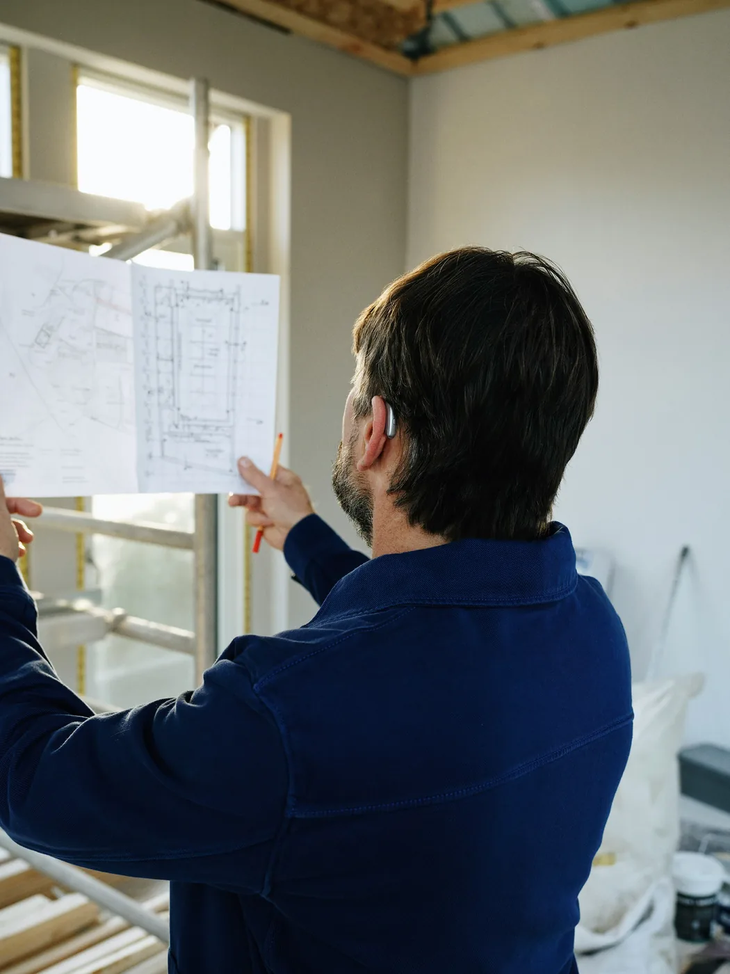 Construction professional reviewing building plans on site